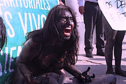 Protests: A woman painted in black screams as dozens of activists gather in front of Petroperu HQ